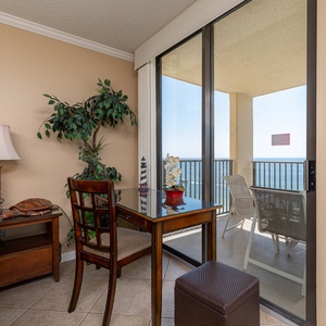 A cozy corner features a wooden desk and chair with a view of the beach, the perfect workspace with complimentary Wifi