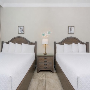 Pull aside curtains to reveal the beach view from this queen guest suite