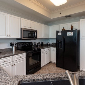 Prepare meals in this spacious kitchen featuring sleek appliances, ample counter space, and stylish cabinetry
