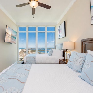 Two queen beds in the guest suite offer plush rest along with sweeping views of the coast beyond tall windows