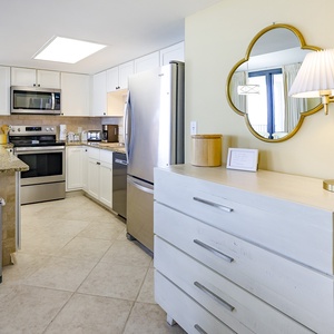 Stylish kitchen features granite countertops, white cabinetry, and a convenient breakfast bar with seating