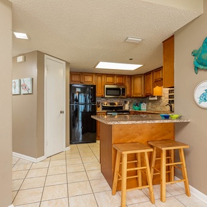 Gather around the kitchen bar with seating, perfect for casual meals and conversation in a welcoming atmosphere