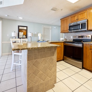 Prepare meals in the inviting kitchen featuring granite countertops and stainless appliances, perfect for your vacation