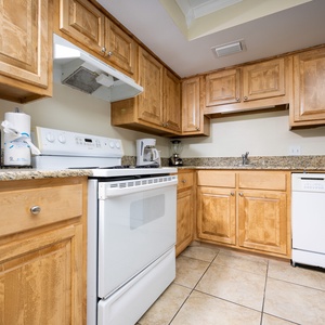 This kitchen features warm wood cabinetry, granite countertops, and stainless appliances, perfect for meal preparation