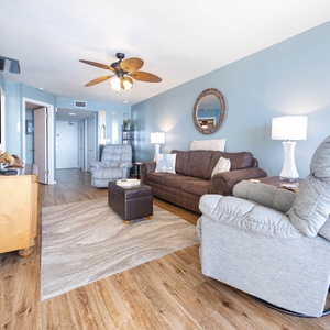 Living room features a brown leather sofa with queen sleeper, cozy recliner, and stylish rug, creating a welcoming atmosphere