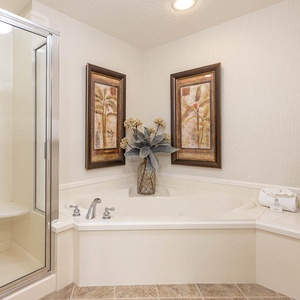 Indulge in relaxation with a spacious jetted tub, elegant decor, and a separate walk-in shower for your comfort