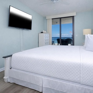 Brightly colored walls complement the inviting king bed in the master, while a balcony offers a serene view of the beach
