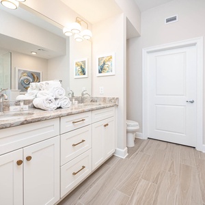 Relax in the master bath featuring a spacious vanity, plush towels, and elegant decor for your comfort