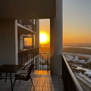 This balcony offers a stunning sunset view, perfect for relaxing with a table and chairs for outdoor dining