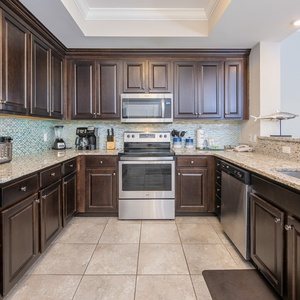 Prepare meals in this kitchen with elegant cabinetry, stainless appliances, and stylish backsplash