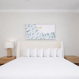 Experience restful nights in this master bedroom with a king bed, soft pillows, and beach balcony access