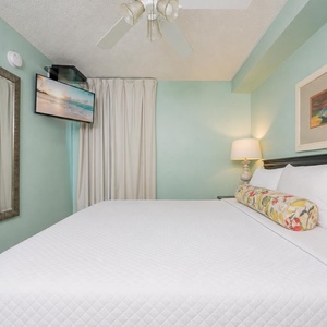 Fluffy pillows invite you to relax in the king suite for a calm movie night after a fun day at the beach