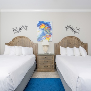 Relax on one of the cozy queen beds in this guest suite with vibrant turtle art and enjoy a peaceful slumber