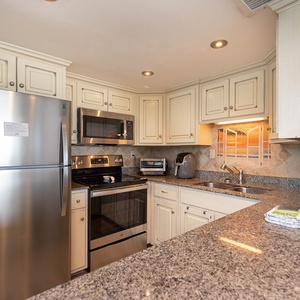 This kitchen features stainless appliances, granite countertops, and a cozy atmosphere perfect for preparing meals