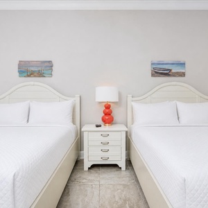 Sink into plush queen beds, then switch on the lamp atop the center nightstand for a quiet read in this guest suite