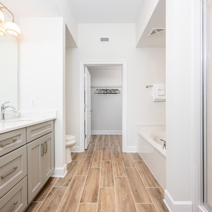 Experience relaxation in the master bathroom featuring a double vanity, a soaking tub, and a glass-enclosed shower