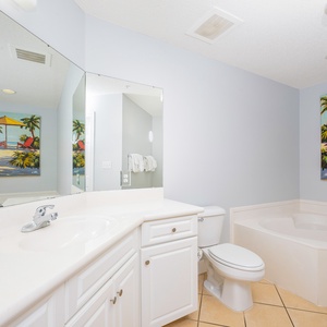 Indulge in a soothing soak in the jetted tub, surrounded by vibrant coastal art that enhances your escape