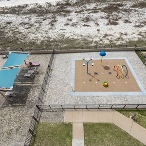 Enjoy the vibrant splash park area with colorful equipment, perfect for kids, alongside the inviting pool for family fun