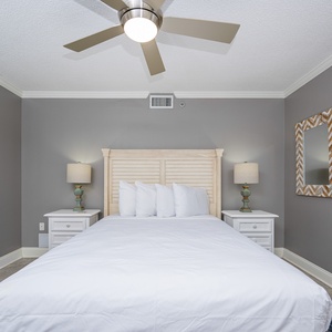 Light gray walls complement the queen bed with nightstands, creating a serene atmosphere in this inviting guest bedroom