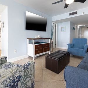 Bright and inviting living area featuring a large TV, cozy seating, additional sleeping, and a charming coastal decor