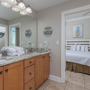 Discover the guest bathroom with dual sinks, stylish decor, and cozy adjoining guest bedroom