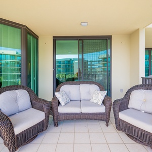 Relax in the cushioned seating on the balcony, basking in the coastal warmth and gentle sounds of the bay