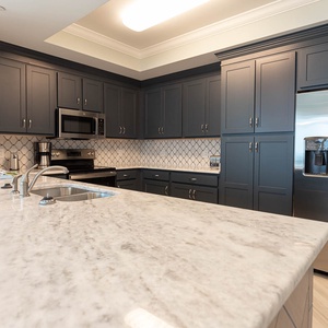 Prepare meals in this kitchen with elegant cabinetry, stainless appliances, and spacious countertops