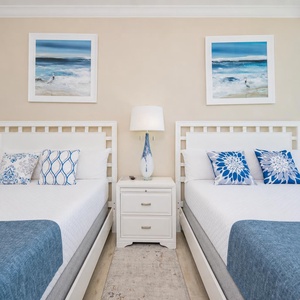Two queen beds in the guest suite invite restful nights with soothing shore views through floor-to-ceiling windows