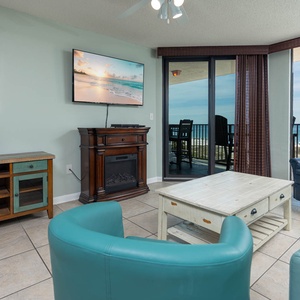 Relax in the inviting living area, featuring cozy seating, queen sleeper sofa, a fireplace, and a view of the beach