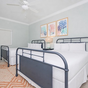 Enjoy restful nights in this inviting guest room with two queen beds, stylish decor, and cheerful artwork