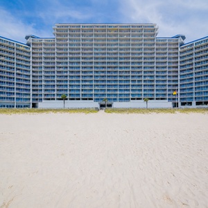 Relax on the sandy beach with colorful umbrellas and lounge chairs, just steps away from your beachfront getaway