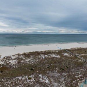 Expansive views showcase the tranquil beach and gentle waves, inviting relaxation from the balcony overlooking the shoreline