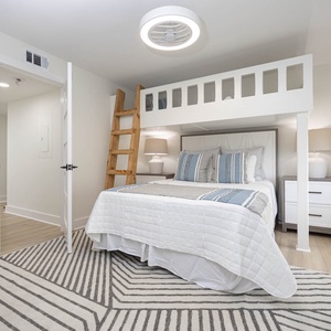 Cozy guest bedroom featuring a queen bed, a stylish ladder to a lofted area with twin bunk overhead, and soft lighting