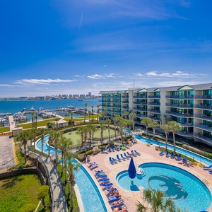 Immerse yourself in relaxation at the pool, with palm trees swaying and the bay shimmering in the distance