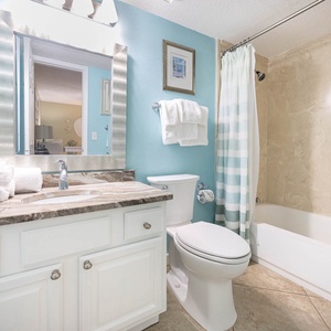 The guest bath features a stylish vanity with a marble countertop, a tub/shower combo, and fresh towels for your convenience