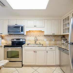 Cream-colored cabinets brighten the kitchen where you gather with family around the granite breakfast bar