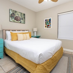Charming guest bedroom with a comfortable queen bed, colorful accents, and inviting decor