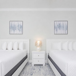 Rest in this tranquil guest room featuring two queen beds, soft linens, and coastal decor