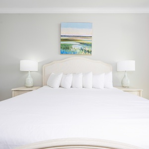 Lie back on the fluffy king bed beneath a serene landscape painting and relax in this master suite