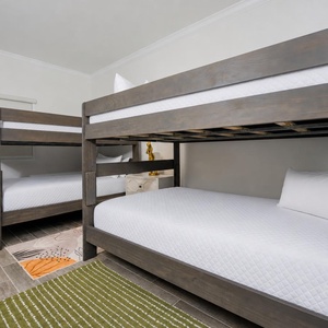 Rest in this cheerful guest room featuring two full over queen bunk beds, soft linens, and a cozy rug