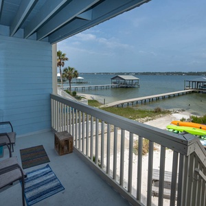 Enjoy a serene lagoon view from the balcony, featuring comfortable seating and vibrant kayaks ready for adventure