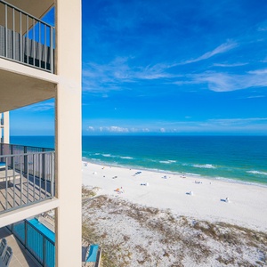 A sweeping view of white beach and turquoise water stretches beyond your balcony on this sunny day