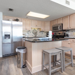 Prepare meals in this inviting kitchen, featuring stainless appliances and a spacious island for gathering and dining