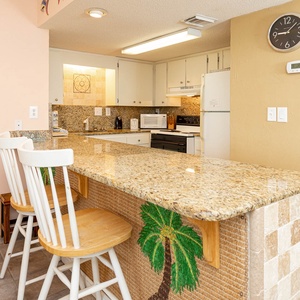 This kitchen features granite countertops, white cabinetry, and a breakfast bar, perfect for casual dining and entertaining