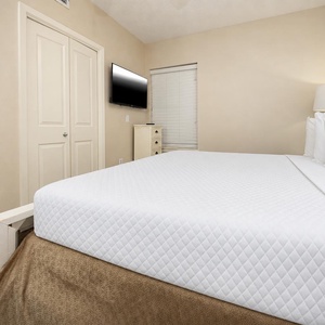 Rest in the comfortable bedroom with a king bed, a flat-screen TV, and soft lighting for a relaxing atmosphere
