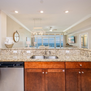 Prepare meals at the granite countertop, with a view of the inviting beach beyond the balcony