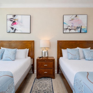 Quiet calm fills the guest suite with two queen beds as you gaze through tall windows at peaceful views