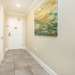 Step into a welcoming entryway adorned with artwork and tile flooring, setting a pleasant tone for your stay