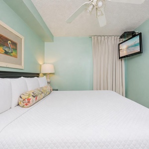 Fluffy pillows invite you to relax in the king suite for a calm movie night after a fun day at the beach