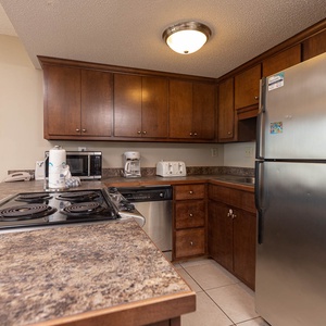 This kitchen features dark wood cabinetry, stainless appliances, and a convenient layout for meal prep and entertaining